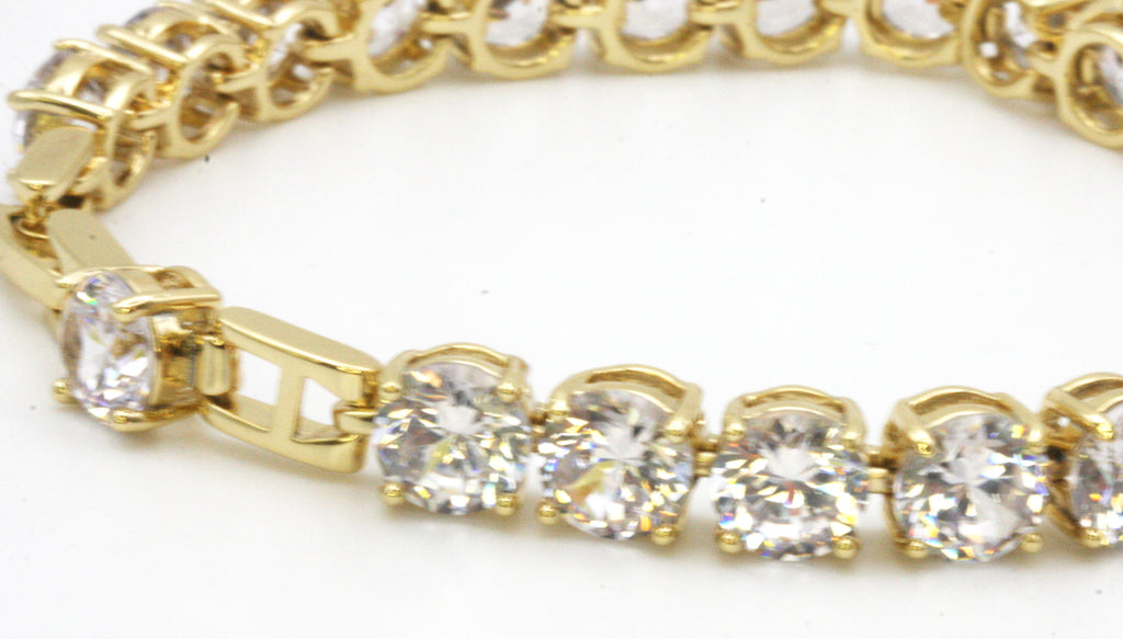 Women bracelet featuring 8 mm clear zircon gemstones. Seven-inch length with a 1/2-inch extension. Yellow gold plated.