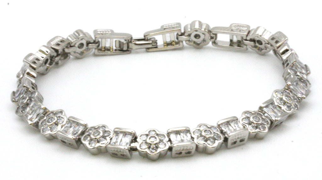 Women's bracelet. Silver/rhodium plated. With alternate blocks and flowers set with zircon gemstones. 6 1/2 inch length with a 1 inch extension.