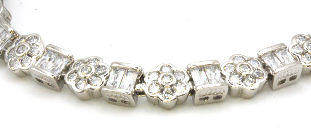 Women's bracelet. Silver/rhodium plated. With alternate blocks and flowers set with zircon gemstones. 6 1/2 inch length with a 1 inch extension.