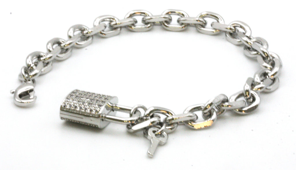Women's bracelet. Chain links with a lock and key charm. The lock is pave set with clear zircon gemstones. Lobster claw closure. 7 inch length. Available in gold or silver/rhodium plating.