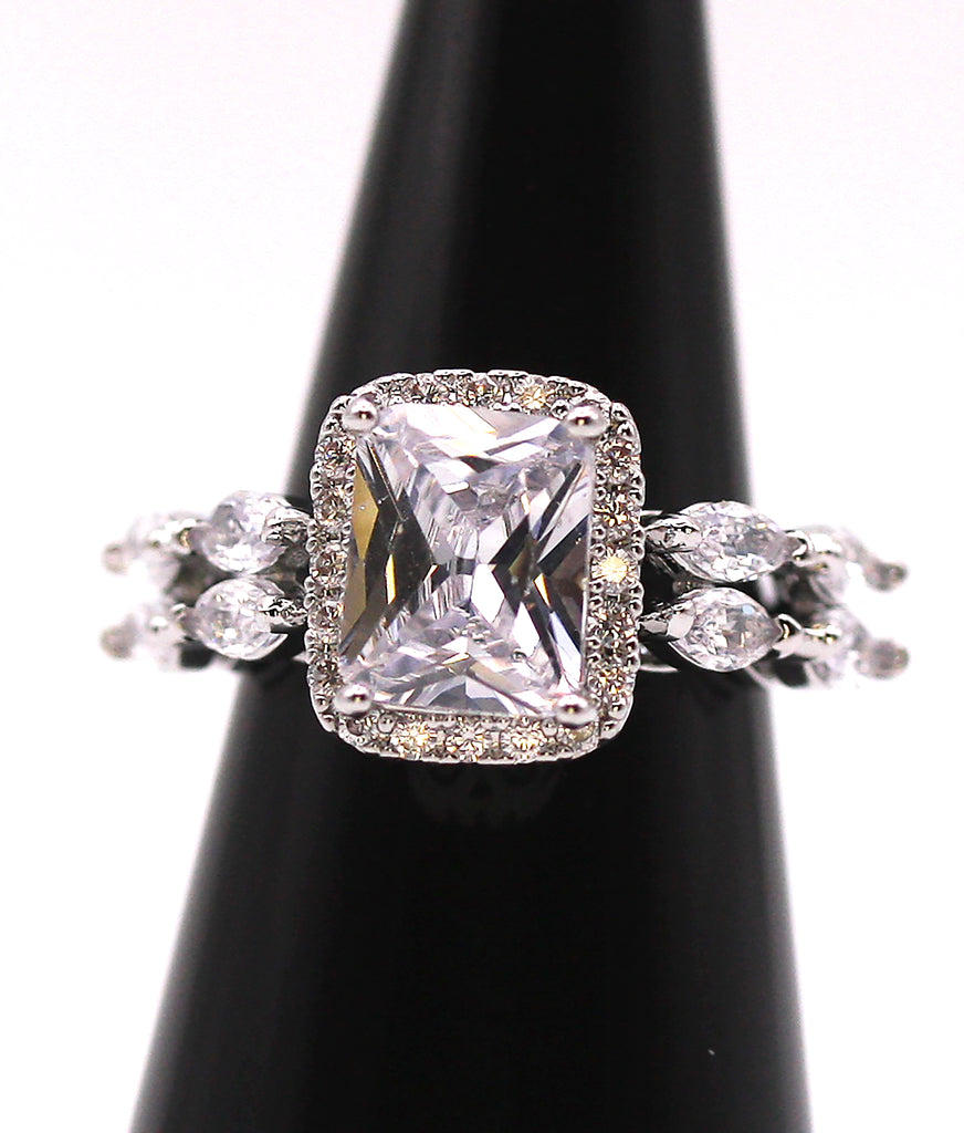 Women's Silver/Rhodium Plated Solitaire Ring with Clear Zircon Gemstones. The solitaire emerald cut zircon is accented with marquise cut and pave set crystals.