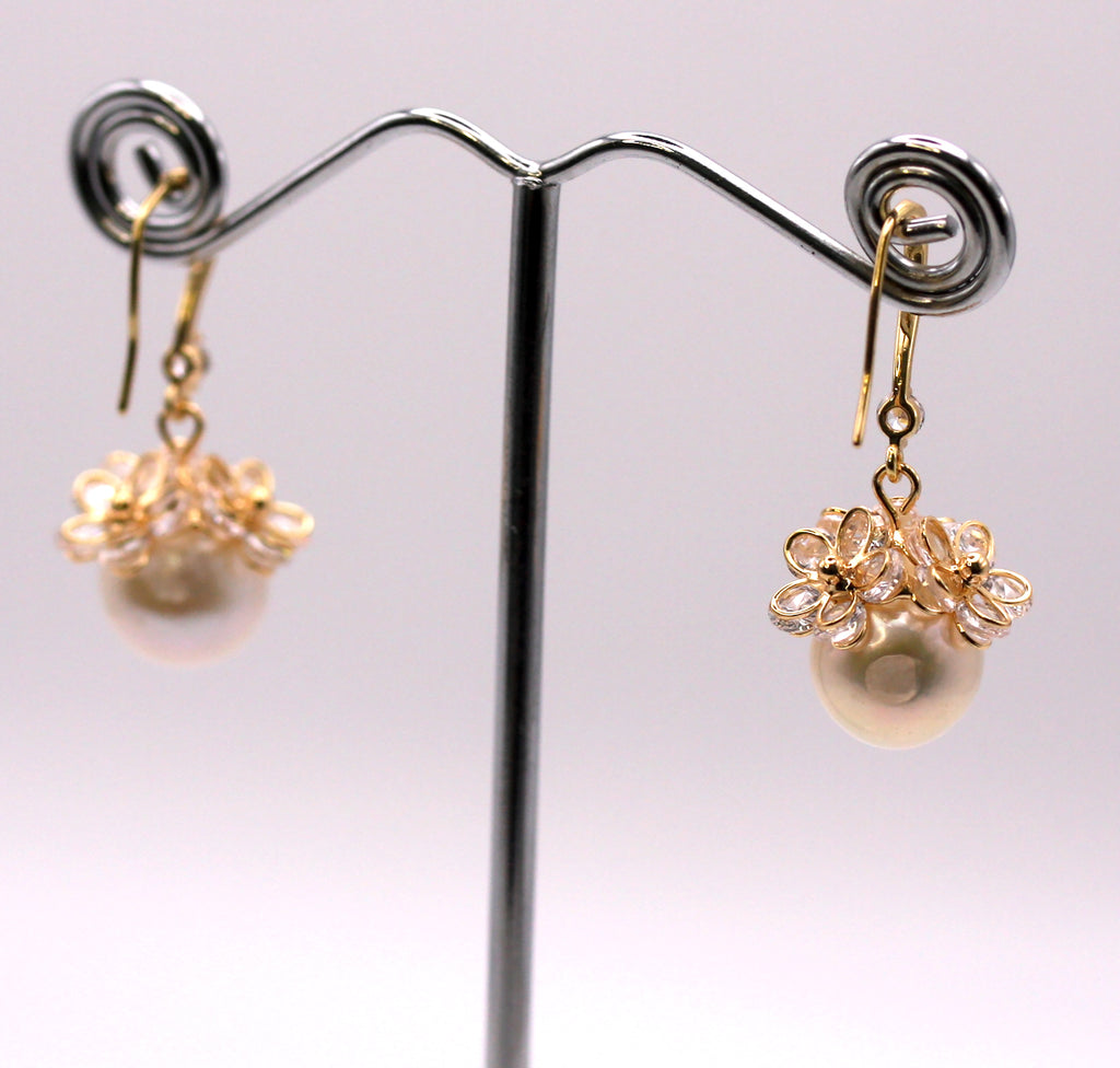Women's Gold Plated Sterling Silver Earrings with Dangling 12 mm white round freshwater Pearls. The white pearl hangs at the bottom of a Sheppard hook set with zircon gemstones and a cluster of three crystal flowers. Rear view