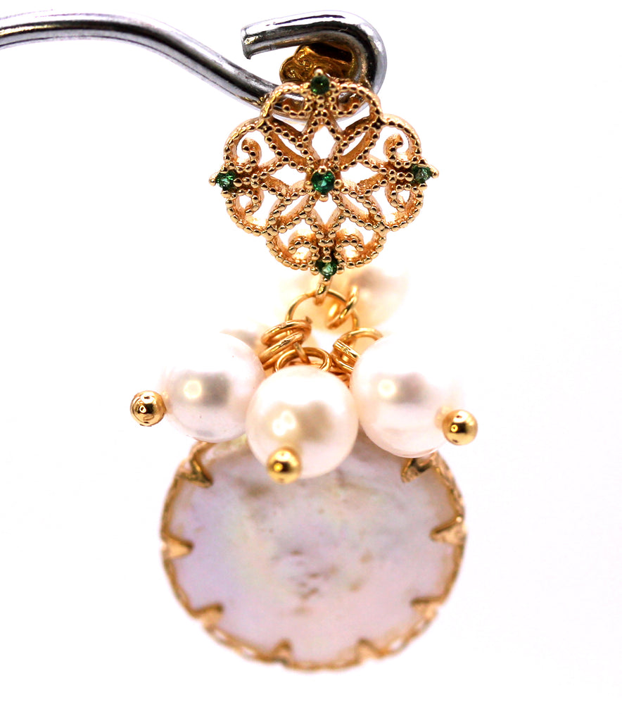Women's Gold Plated Sterling Silver Earrings with Dangling 16 mm decorated Coin freshwater Pearls. The white pearl hangs at the bottom of a top post filigree flower set with five green zircon gemstones and a cluster of five 4 mm white pearls. Face view