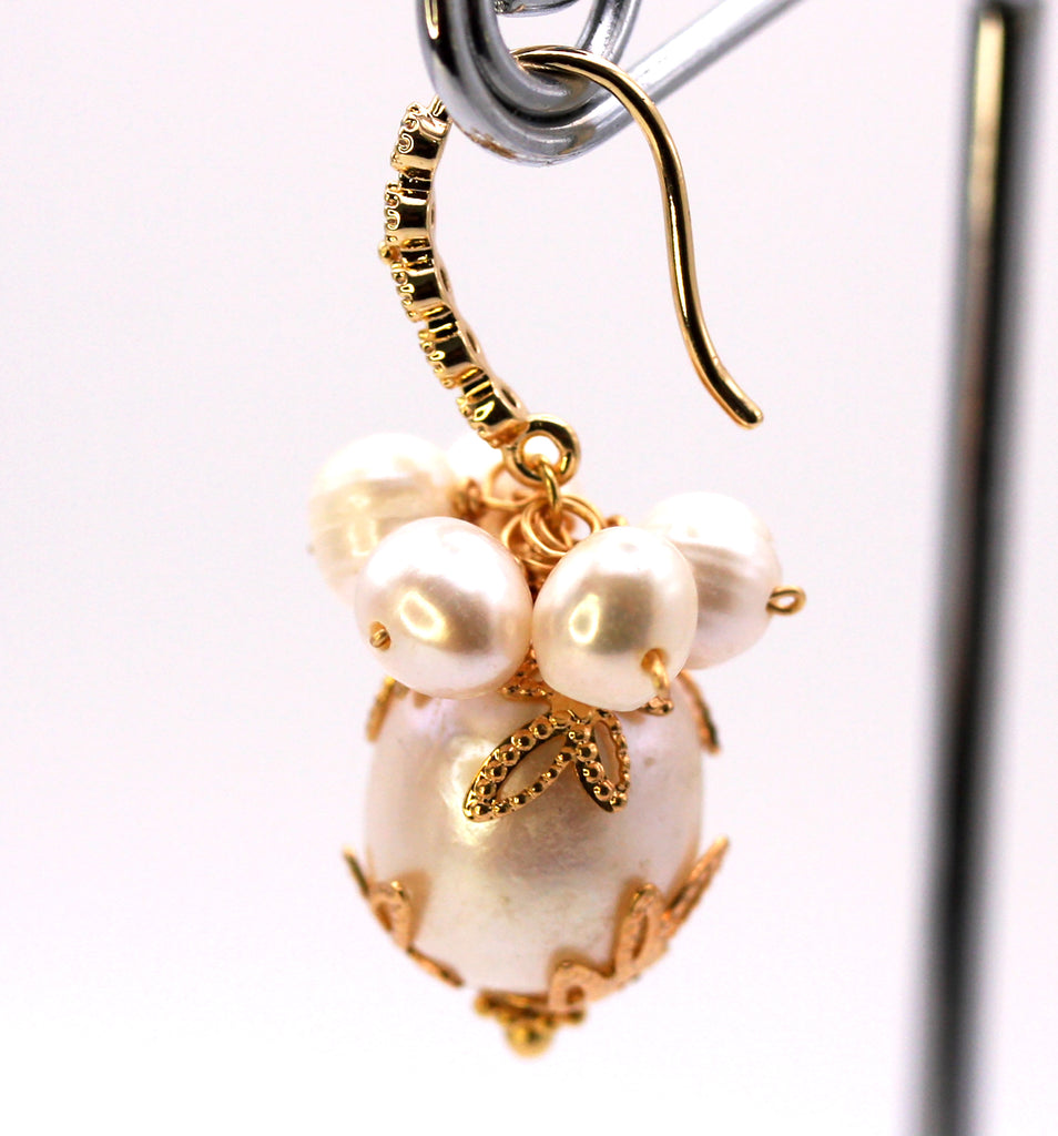Women's Gold Plated Sterling Silver Earrings with Dangling 16 mm decorated Baroque freshwater Pearls. The white pearl hangs at the bottom of a Sheppard hook pave set with zircon gemstones and a cluster of five 4 mm white pearls. Side view
