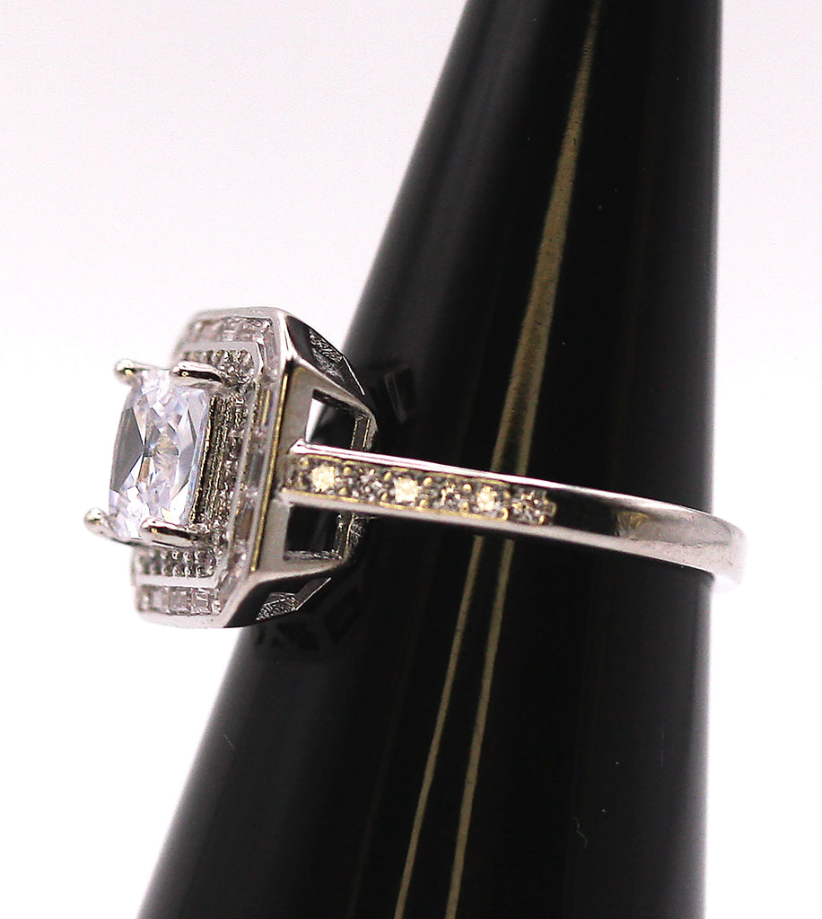Women's Silver/Rhodium Plated Square Cut Solitaire Ring with Clear Zircon Gemstones. The solitaire is accented with one square of baguette cut crystals and on square of pave set crystal stones on the face of the ring. The band is also accented with pave set zircons. Side view